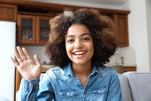Smiling teenager student reciving an online class